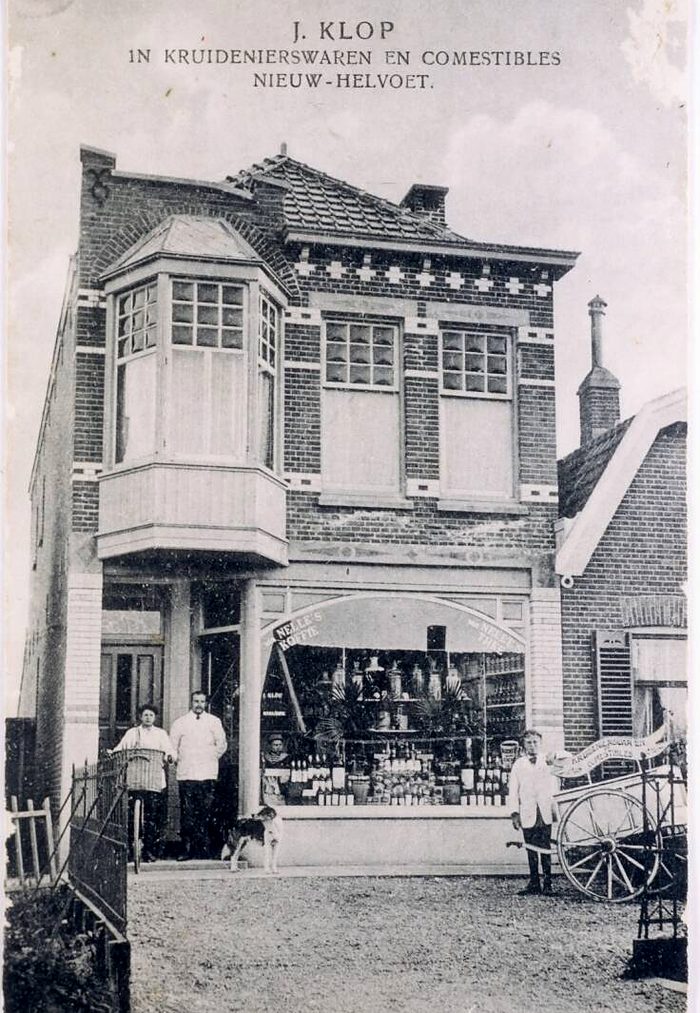 Oude foto van de winkel van J. Klop, kruidenierswaren en comestibles, met de winkeliers voor de deur