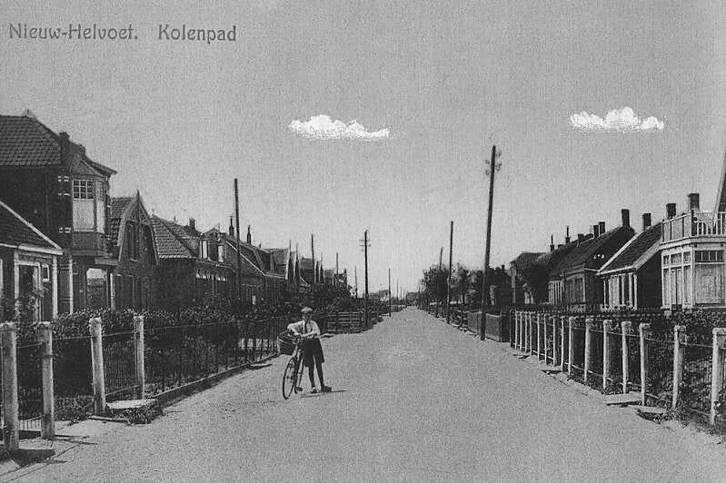 Oude ansichtkaart van het Kolenpad in Nieuw-Helvoet, een zandweg met huizen en een man met een fiets